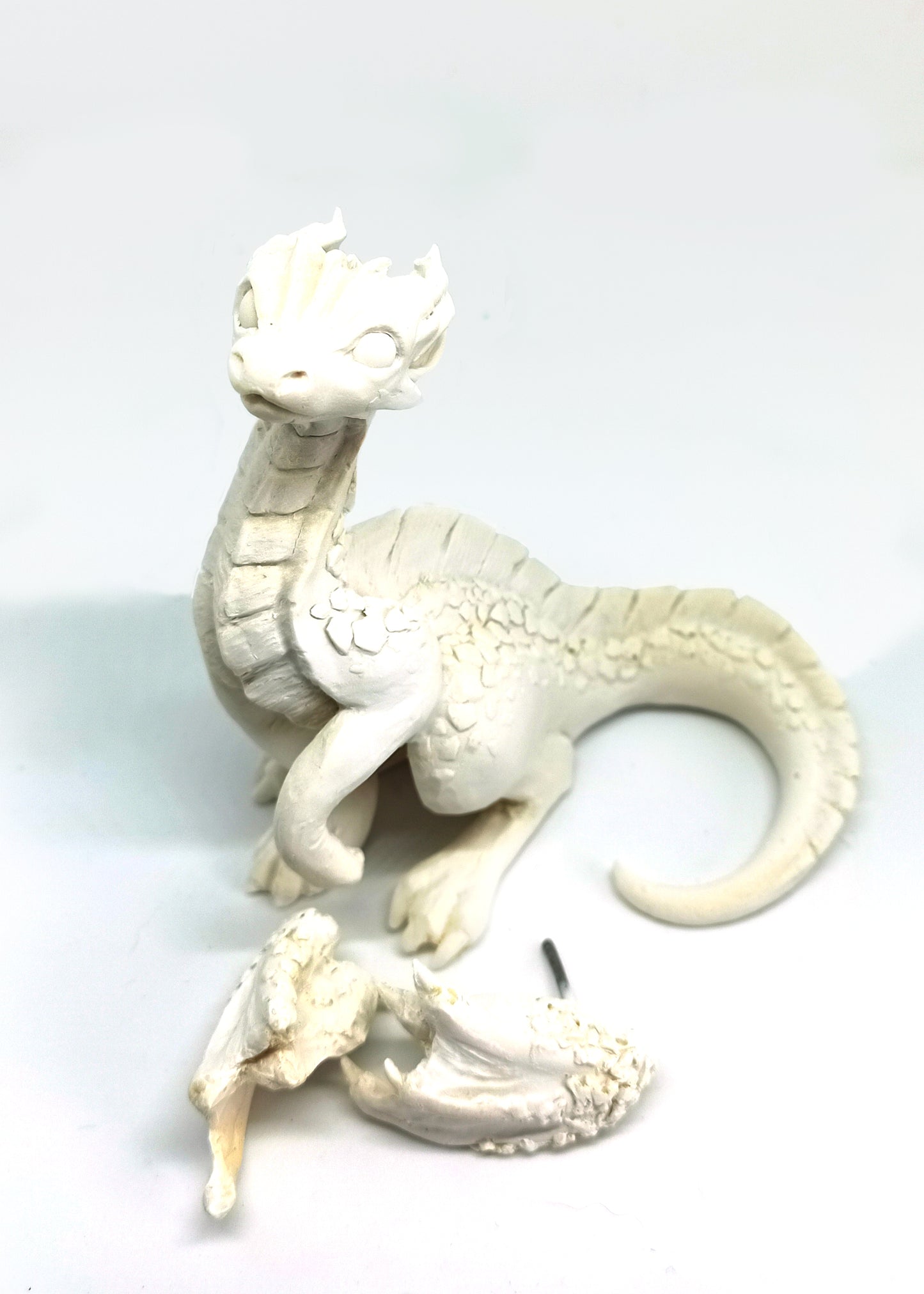 Unpainted sitting down dragon figurine to customize