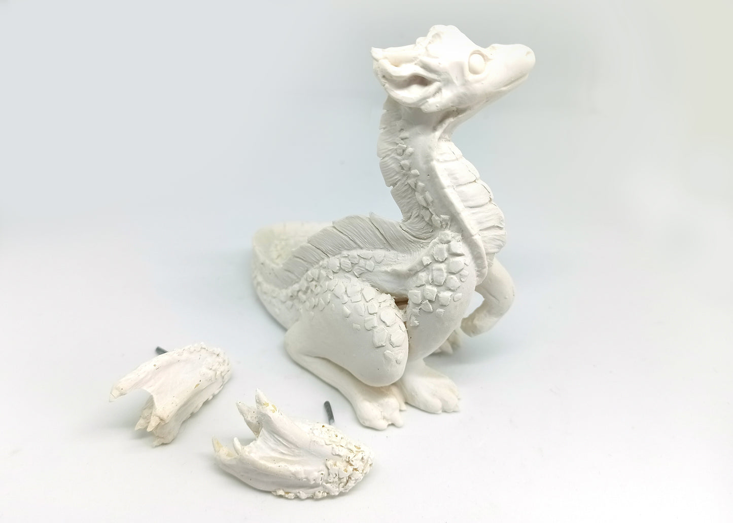 Unpainted sitting down dragon figurine to customize